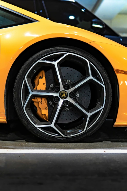 yellow sports car with custom rims parked next to other vehicles