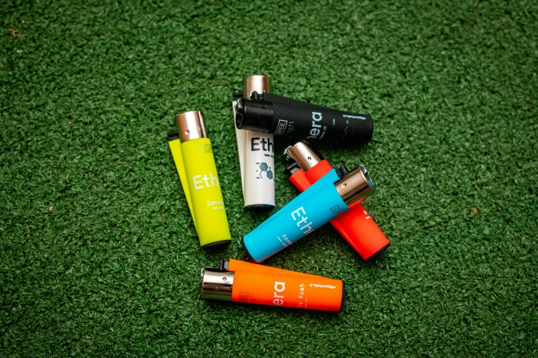 five small batteries are sitting next to each other on green grass