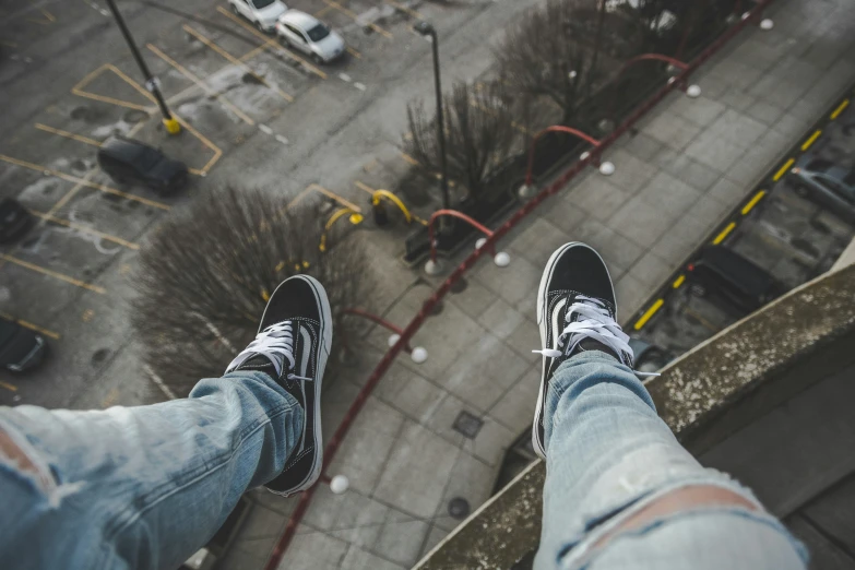 person standing on ledge overlooking parking lot near intersection