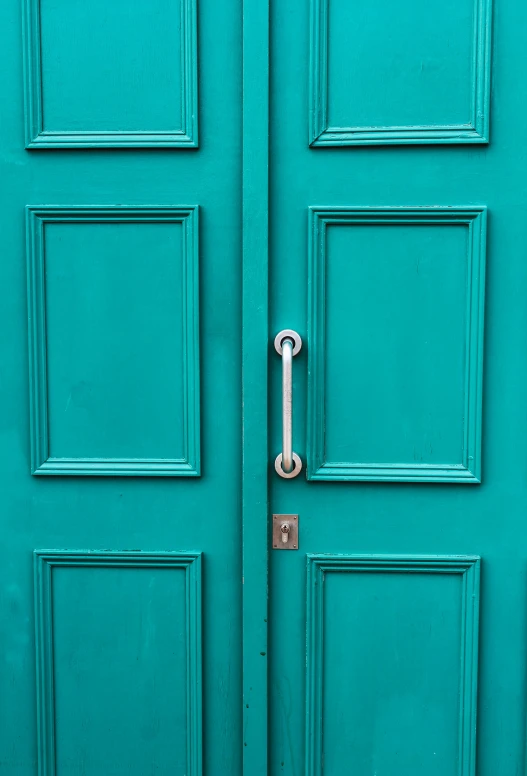 an open green door with a key handle
