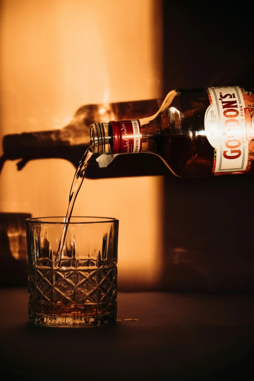 a person is pouring a glass of coke in front of a wall