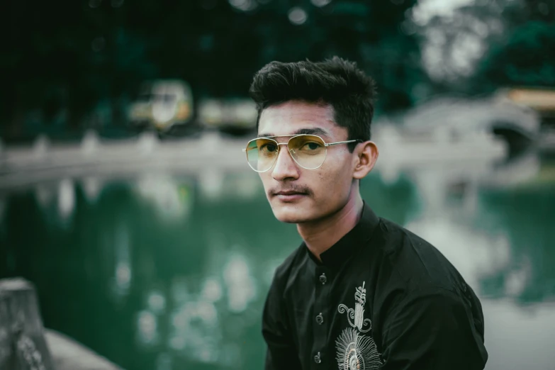 a man sitting down and wearing some sunglasses