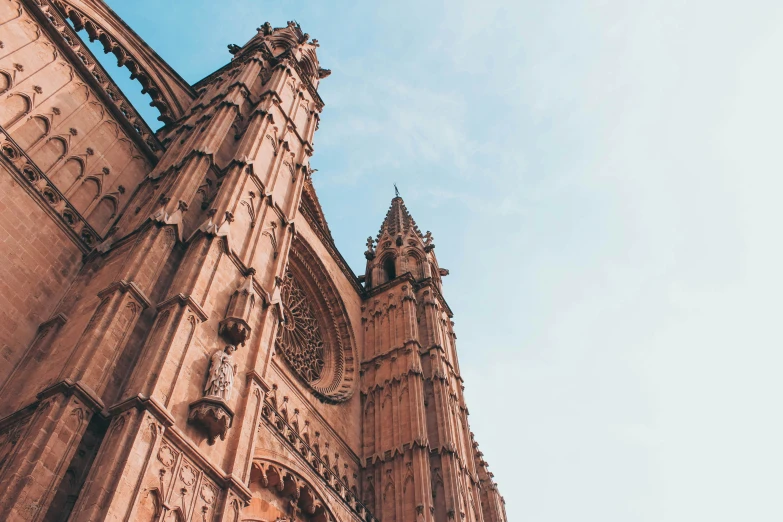 a tall cathedral with several statues at the top