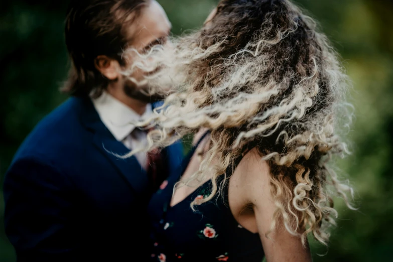 a man and woman emcing while the couple holds each other close together