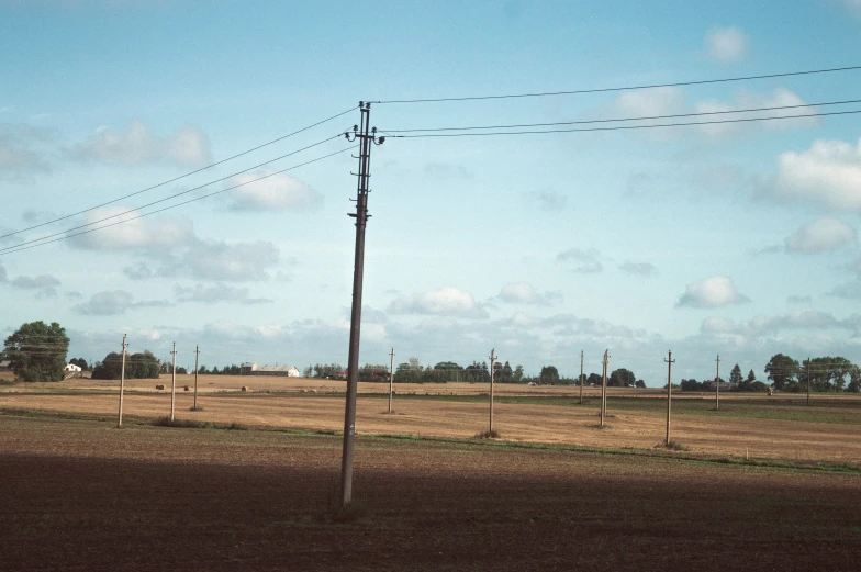 a telephone pole in a rural area with no power lines on the other side