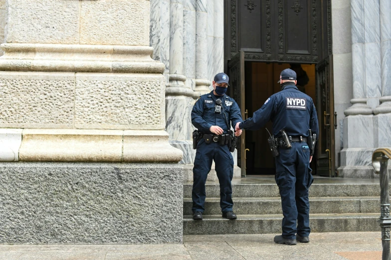 a couple of police officers standing next to a building