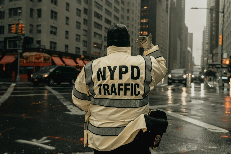 a man holding an umbrella and directing traffic