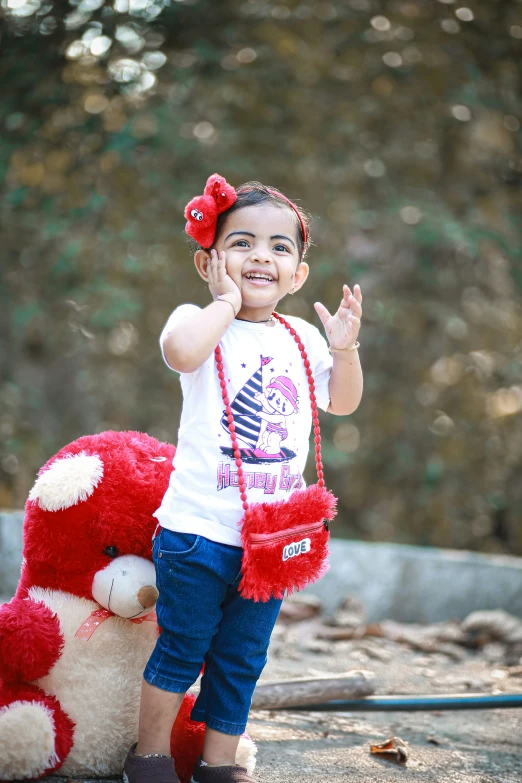 little girl standing on top of stuffed teddy bear