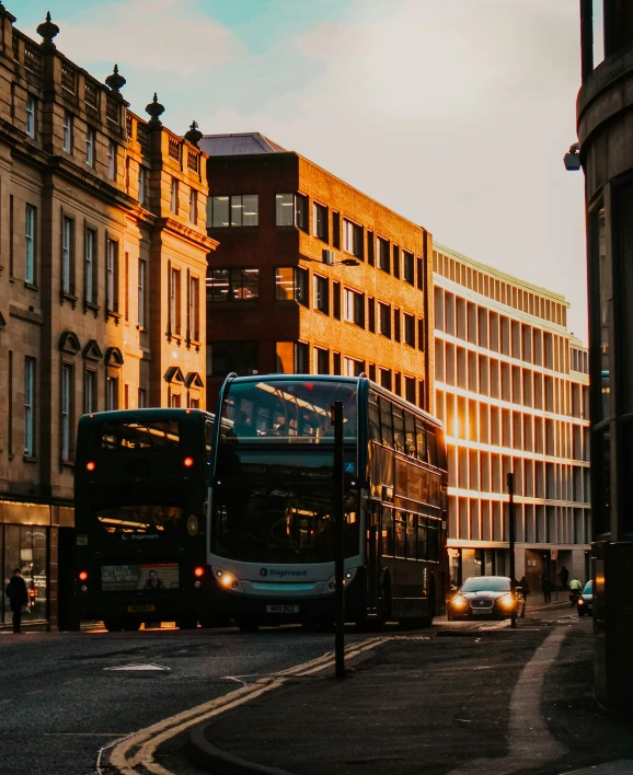 two double decker buses driving in front of some buildings