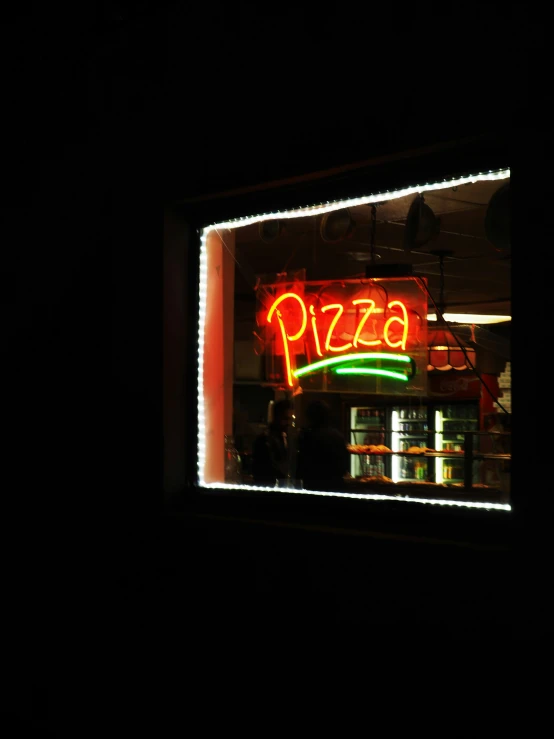 a restaurant sign with lighted text reading pizza