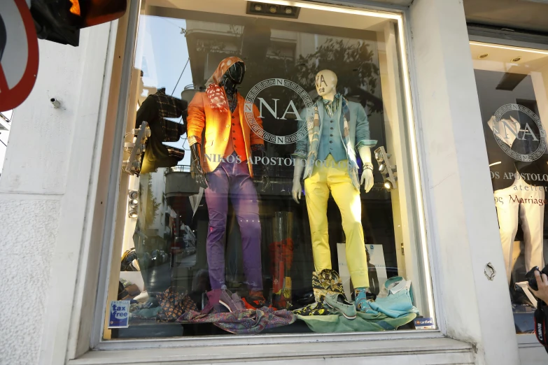 a store front window is decorated with many outfits