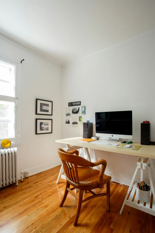 a computer desk in front of a large window