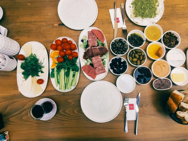 an array of various dishes and dishes of food on a wooden table