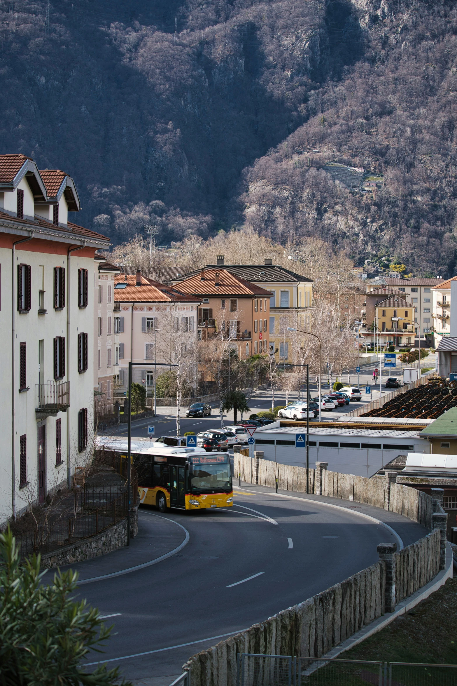 a bus travels down the street in an area with houses and hills