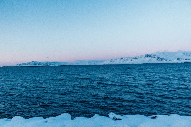 the water is very blue with some ice on it