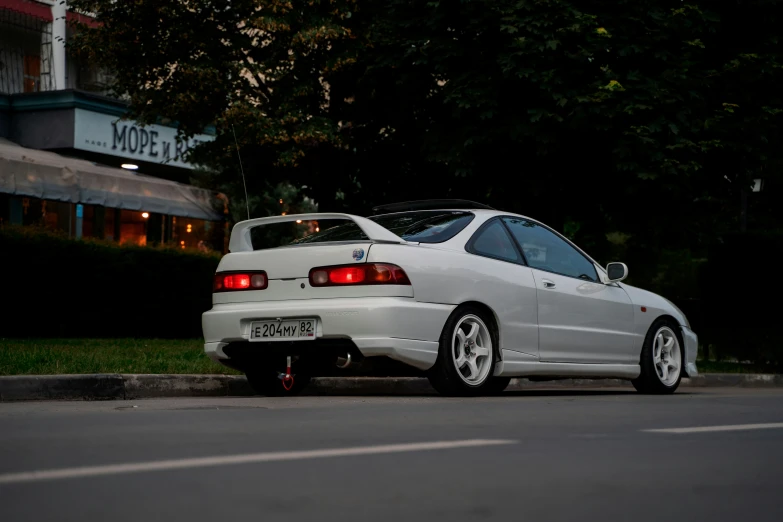 a white car is parked in front of the street