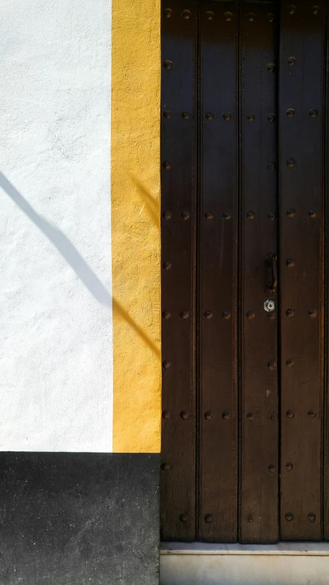 a door and side of a building with white and yellow walls