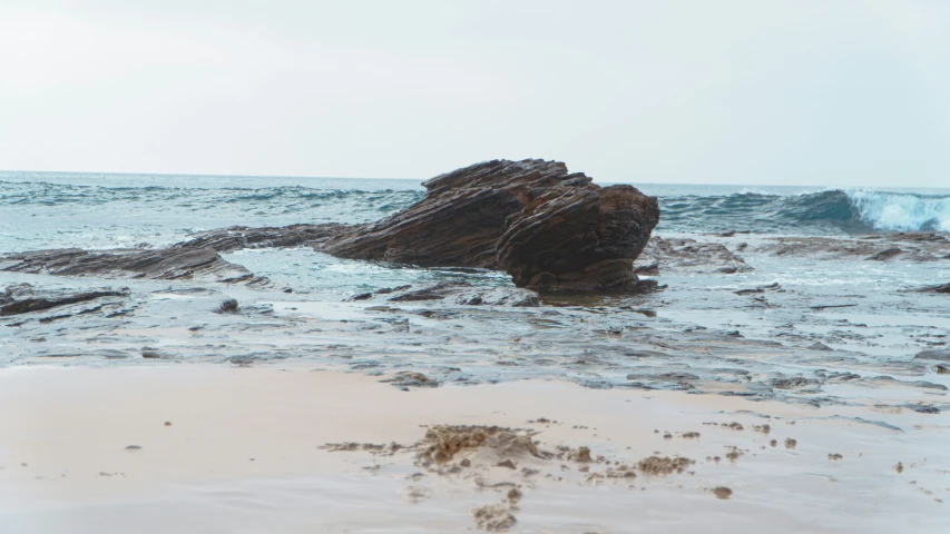 a large rock sticking out of the middle of the ocean