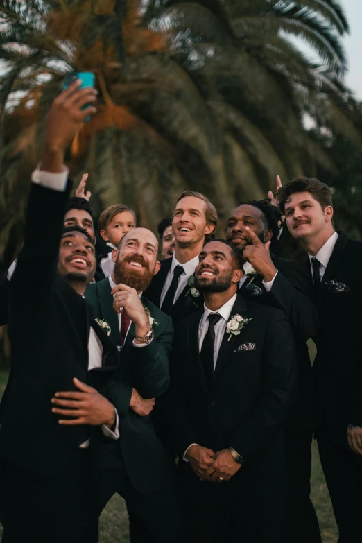 a group of men in tuxedos pose for the camera