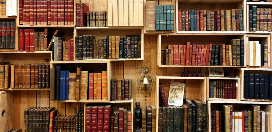 a bookshelf with many books and a clock on the side