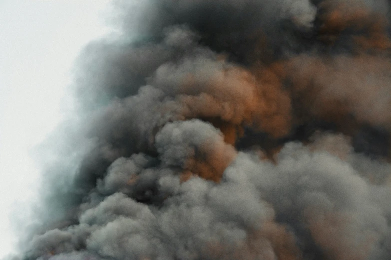 the black smoke is being emitting from the smoke stack