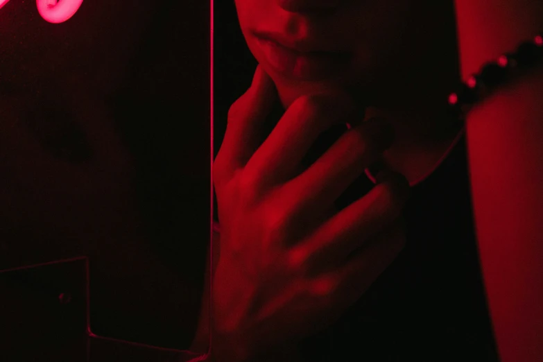 a close up of a person standing in front of a red light