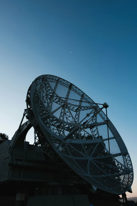 a satellite dish is seen at sunrise in silhouette