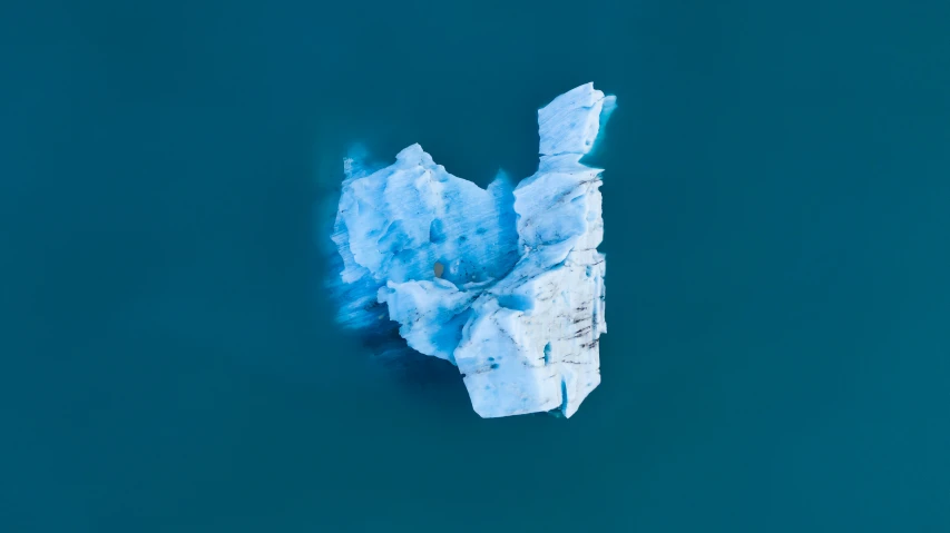 an iceberg floats in the ocean near land