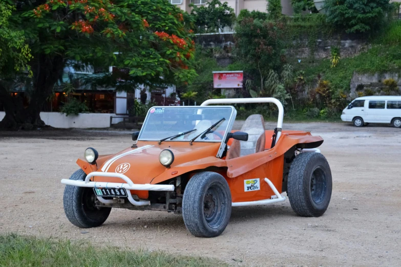 an orange and white two seat three wheeled vehicle