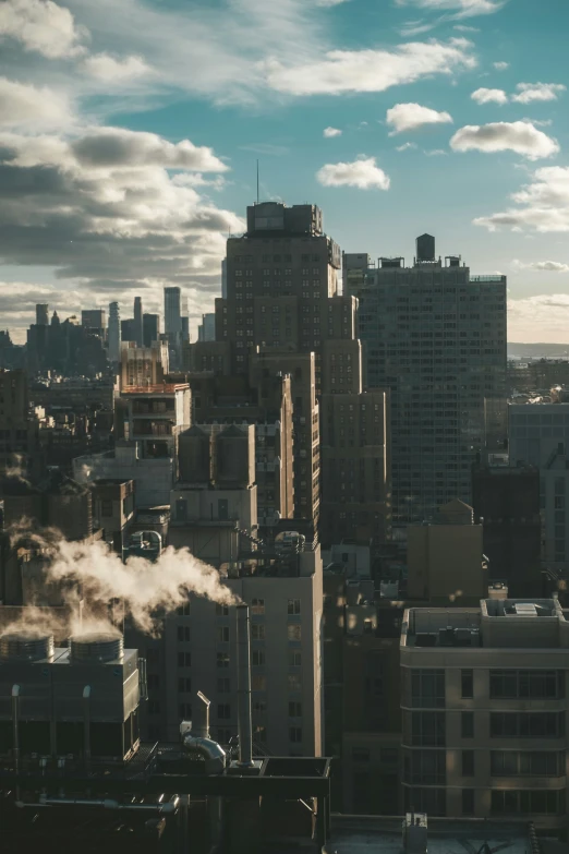 a steam rises from the chimneys of high rise buildings