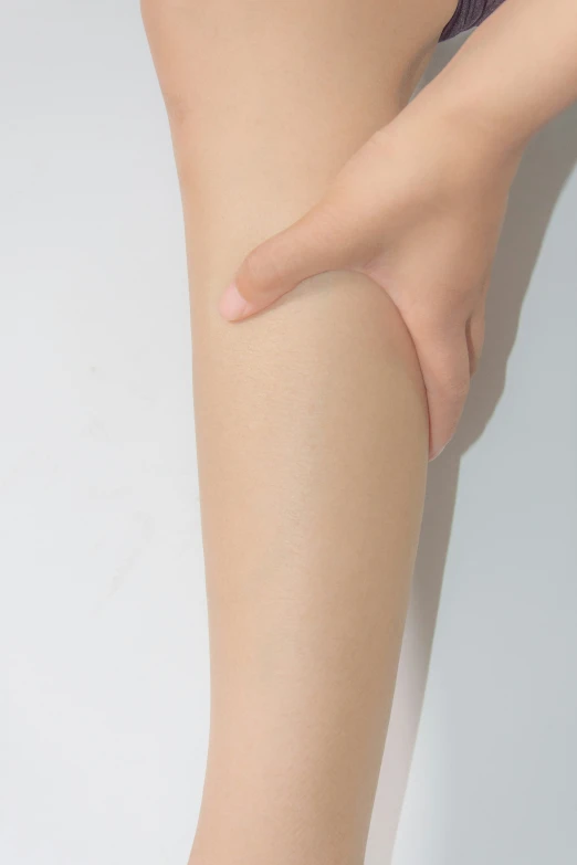 a woman's legs with a cellphone on her arm