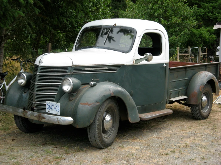 an old pick up truck is parked near trees