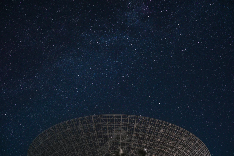 very large satellite dish in a remote area with many stars