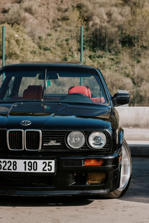 a black car parked next to a forest filled mountain