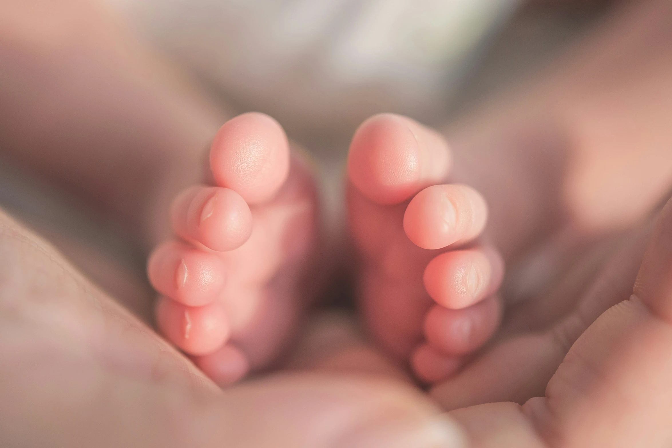 a close up of the feet and hands of two baby feet