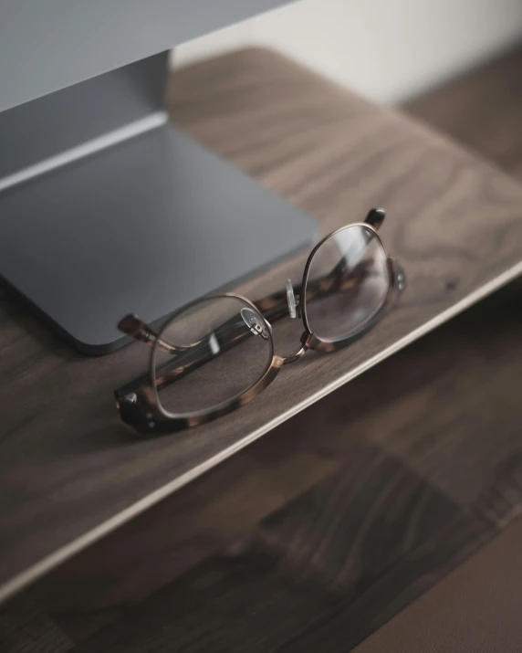 a pair of glasses sitting on top of a laptop computer