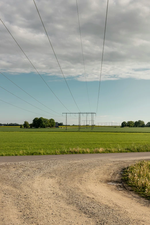 a rural road and power line across from a field