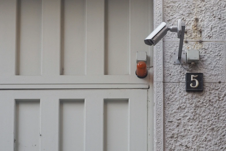 a couple of security cameras mounted to a white door