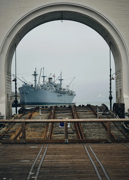 a large boat sailing next to a wooden bridge