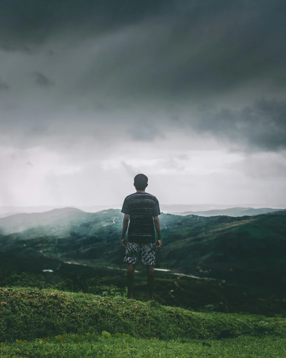 a man is standing on top of a hill in the rain