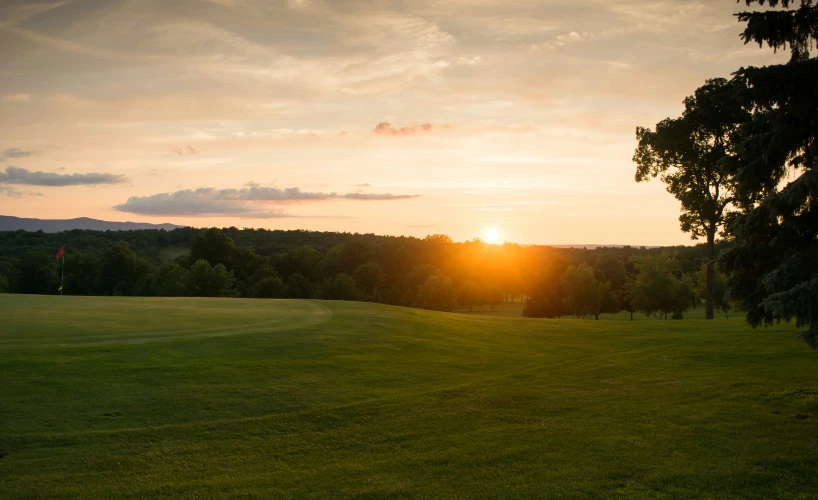 the sun is shining on some green field