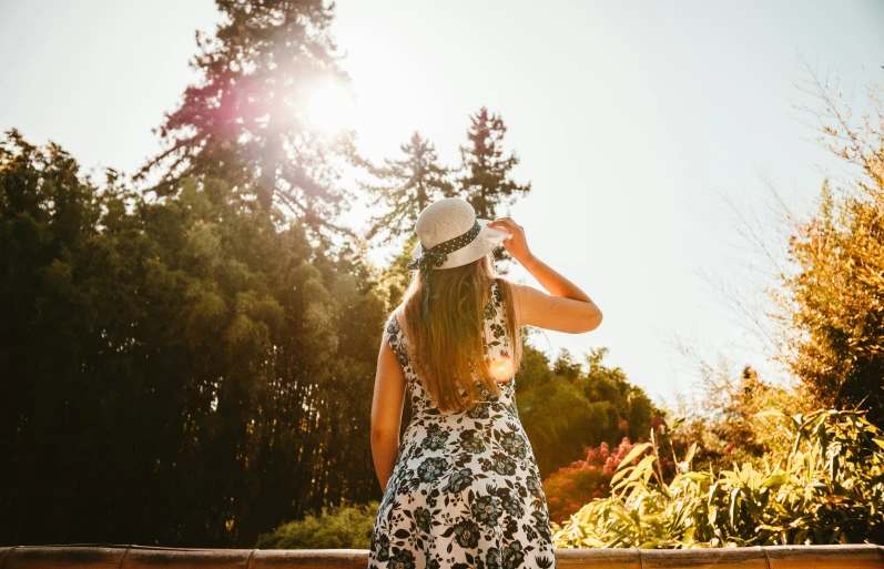 girl in patterned dress walking towards the woods