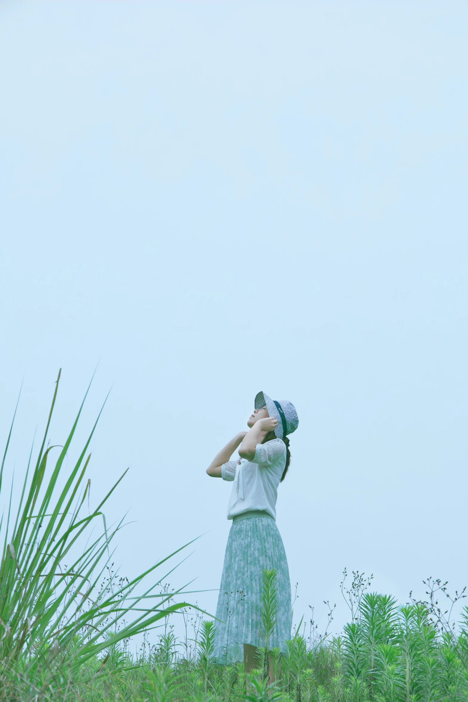 a young woman is standing on a grass hill with a golf club