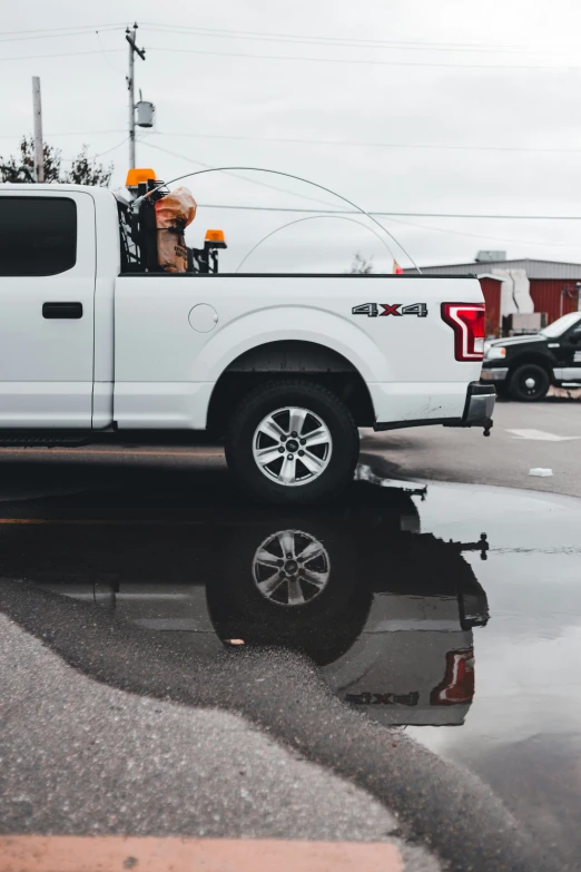 a white truck driving down a street past traffic lights