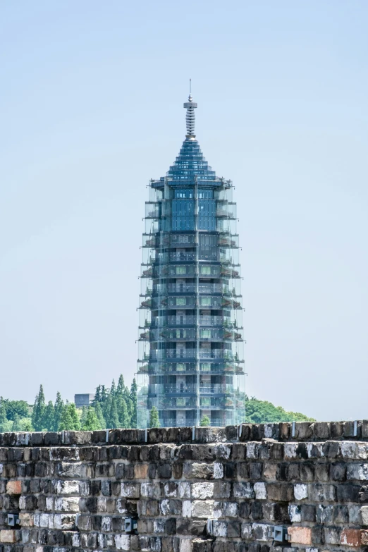 a tall tower covered in scaffolding sitting over a lush green forest