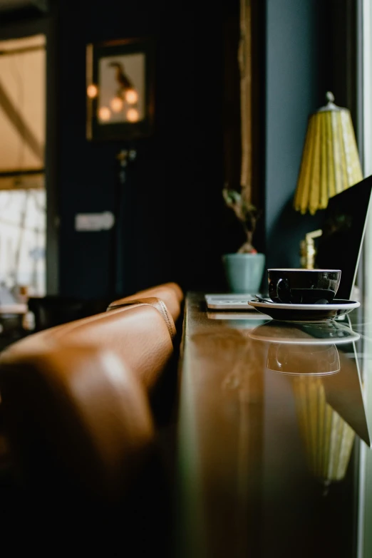 a laptop and an empty cup sitting on a glass table