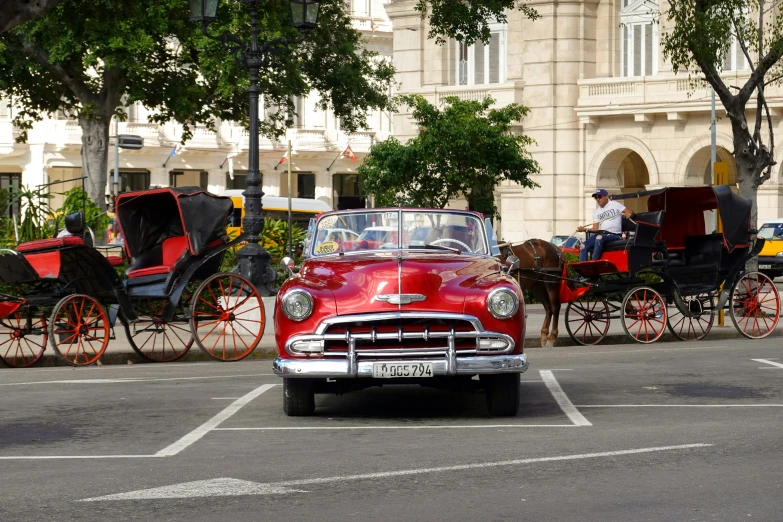 the antique car is being driven by some horse