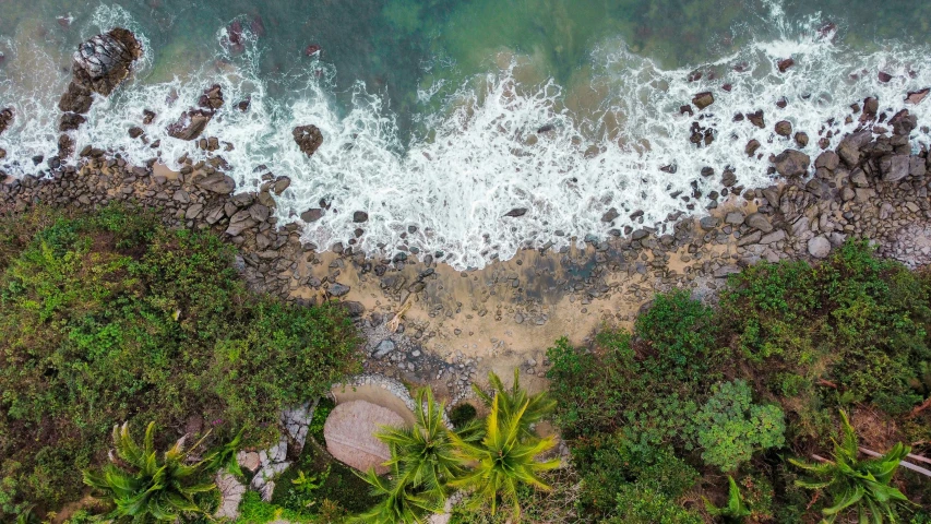 an aerial view of a beach near some water