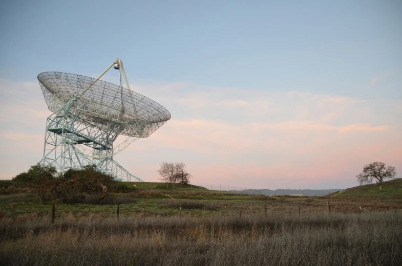 two large antennas with wires in an open field