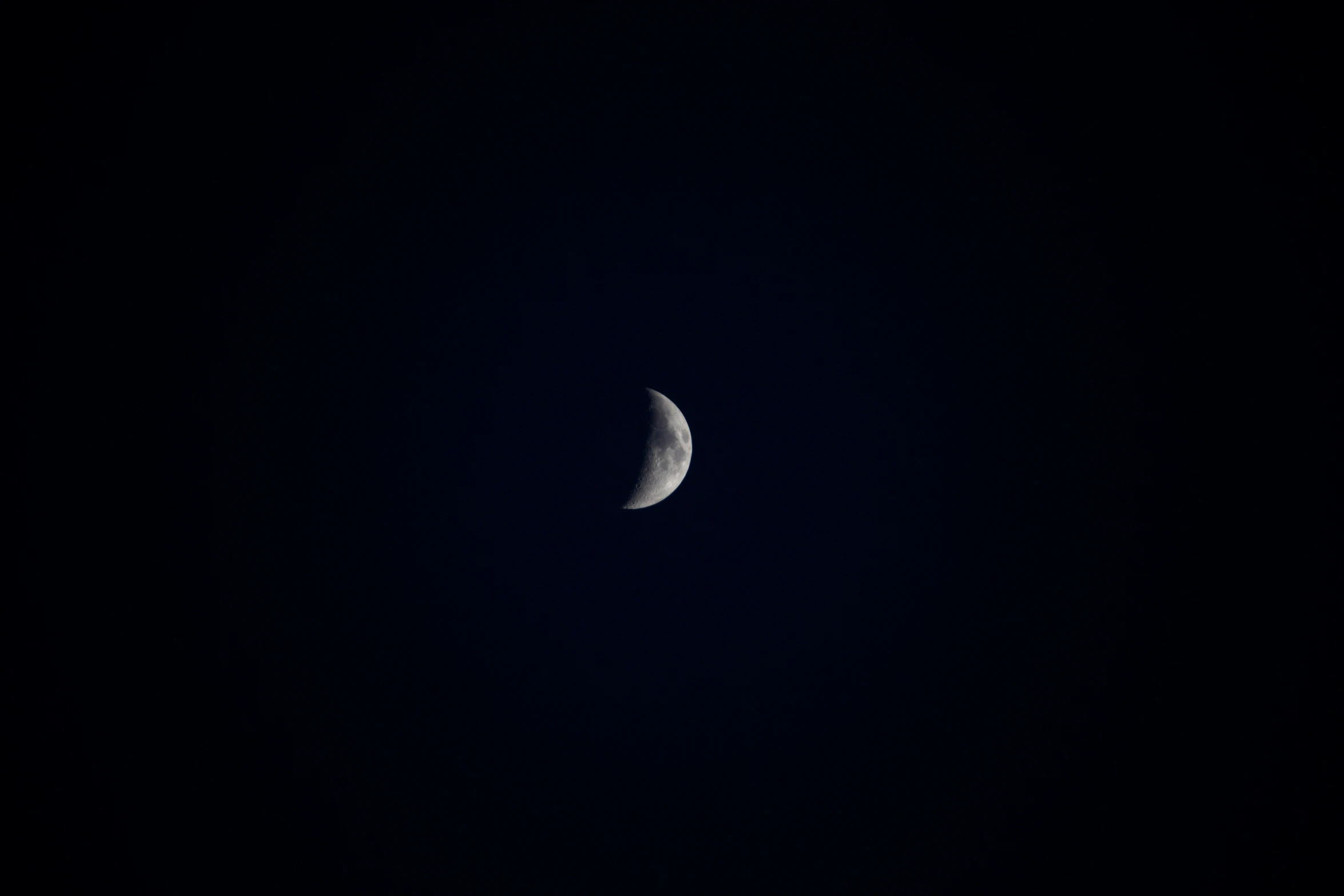 a half - moon is seen during the night sky